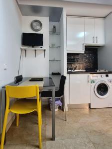 a kitchen with a table and a yellow chair at Mini Apartamento Lovely Chueca in Madrid