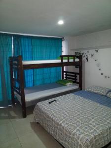 1 dormitorio con 2 literas y cortinas azules en Del Castillo Mirador Hostel, en Cartagena de Indias