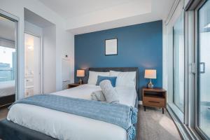 ein Schlafzimmer mit einem großen Bett mit blauer Wand in der Unterkunft York Apartments ( 2) in Toronto
