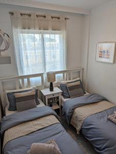 a bedroom with two twin beds and a window at 2 Bedroom Algorfa Townhouse with Pool in Castillo de Montemar +62 photos