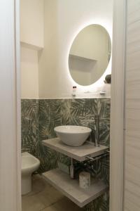 THE SUN HOTEL BOUTIQUE NAPOLI في نابولي: حمام مع حوض ومرآة