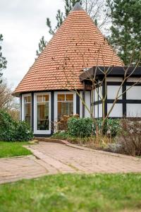 a small house with a tiled roof in a yard at Ferienwohnung Kleiner Storch - Seehotel Dümmer in Hüde