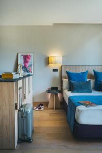 a hotel room with two beds and a suitcase at The Oliver Apartamentos Aravaca in Madrid