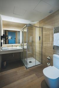 y baño con ducha, aseo y lavamanos. en The Oliver Apartamentos Aravaca, en Madrid