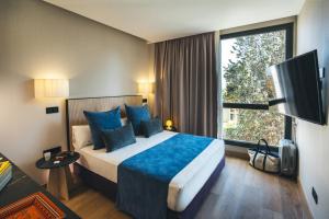 a hotel room with a bed and a large window at The Oliver Apartamentos Aravaca in Madrid