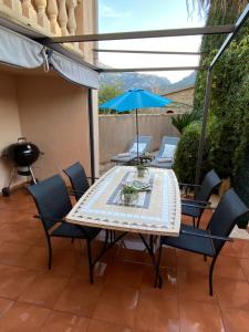 索列爾的住宿－Can Domingo，庭院里配有桌椅和遮阳伞