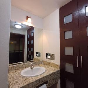 a bathroom with a sink and a mirror at Sleep Inn Puebla Centro Historico in Puebla