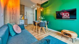 uma sala de estar com um sofá azul e uma mesa em Apartament Schellter 62 przy Wydmach - by 5D Apartamenty em Rogowo