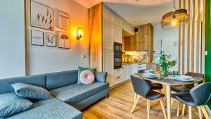 uma sala de estar com um sofá e uma mesa em Apartament Schellter 62 przy Wydmach - by 5D Apartamenty em Rogowo