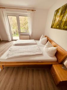 a bedroom with two beds and a large window at Hotel | Restaurant | Forellenzucht in Burgen