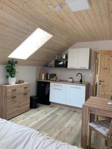 uma cozinha com armários brancos e piso em madeira em Penzion Pod pecí em Lenora
