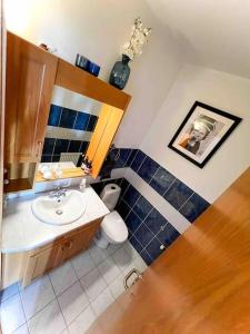 a bathroom with a sink and a toilet and a mirror at Family friendly home close to golden circle and to city central! in Reykjavík