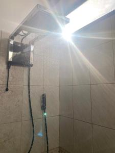 eine Dusche mit Sonne, die durch eine Dusche leuchtet in der Unterkunft Moderno, grande, amplia vista, parqueo in Machala