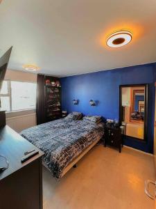 um quarto com uma parede azul e uma cama em Family friendly home close to golden circle and to city central! em Reykjavík