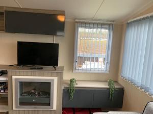 a living room with a tv and a fireplace at Littlesea Haven Rachel's Retreat in Wyke Regis