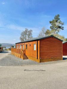 uma grande cabana de madeira com uma escada ao lado em Windermere View Lodge - White Cross Bay em Windermere