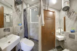 een badkamer met een wastafel, een toilet en een douche bij FlxHo Quad - Luxury Studio Apart Hotel DLF Cyber City in Gurgaon