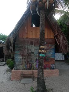 a building with graffiti on it next to a palm tree at cabana sabiá in Camaçari