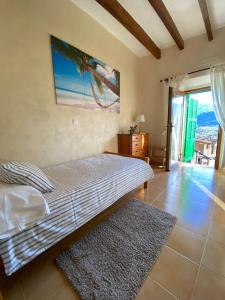 a bedroom with a bed and a large window at Can Domingo in Sóller