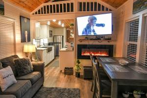 a living room with a couch and a tv on a wall at Sweet Creek Retreat in Turtletown