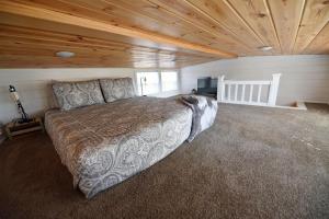 a bedroom with a large bed in a room with wooden ceilings at Sweet Creek Retreat in Turtletown