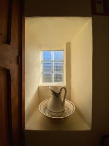 a white vase sitting on a plate in a window at Can Domingo in Sóller