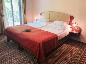 a bedroom with a large bed with a red blanket at Parkhotel Forest in Mariánské Lázně