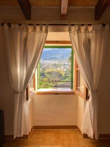 a window with curtains in a room with a view at Can Domingo in Sóller