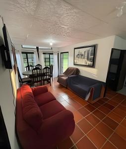 sala de estar con sofá y mesa en Cabaña Campestre de con piscina, cocina, y wifi., en Carmen de Apicalá