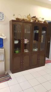 un armario de madera con puertas de cristal en una habitación en Loidas place, en Talisay