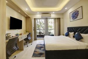 1 dormitorio con 1 cama y escritorio con ordenador en FlxHo Quad - Luxury Studio Apart Hotel DLF Cyber City, en Gurgaon