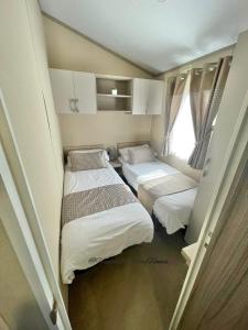 ウィンダミアにあるWindermere View Lodge - White Cross Bayのベッド2台と窓が備わる小さな客室です。