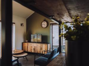 UitgeestにあるHouse by Uitgeestermeer with Gardenのテーブルと時計付きの部屋