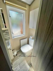 a small bathroom with a toilet and a window at Windermere View Lodge - White Cross Bay in Windermere +10 photos