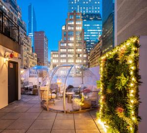 a patio with tables and chairs in domes with lights at Little Charlie Hotel in New York