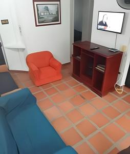 sala de estar con silla naranja y armario en Casa de descanso, estudio o trabajo, cocina y wifi, en Carmen de Apicalá