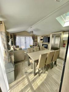eine Küche und ein Wohnzimmer mit einem Tisch und Stühlen in der Unterkunft Windermere View Lodge - White Cross Bay in Windermere