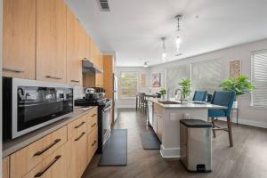 una cocina con armarios de madera y una isla con microondas en Lux 3BR Near Truist Park & Mall en Atlanta