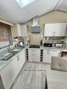 a kitchen with white cabinets and a counter top at Windermere View Lodge - White Cross Bay in Windermere