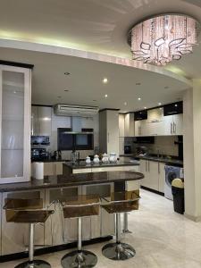 a large kitchen with a large island with bar stools at Zahran Apartment VIP شقة فندقية فاخرة in Cairo