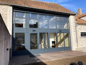 a large glass garage door on a building at Les logis du Parc in Bullion