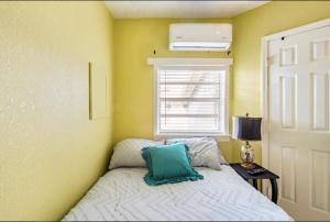 a bedroom with a bed with a blue pillow on it at 3-Bed Bungalow walk to Historic Downtown Sanford in Sanford