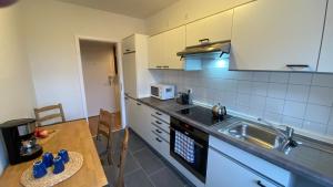 uma cozinha com uma mesa, um lavatório e um balcão em CHARLIE , Solingen Mitte, Ferien/Messe Wohnung für bis zu 5 Personen em Solingen