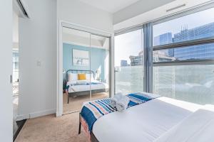 a bedroom with a bed and a large window at Downtown Apartments 3 in Toronto