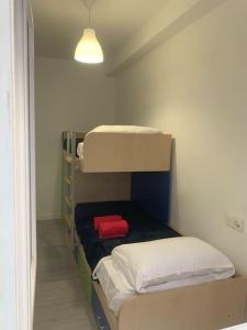 a room with two bunk beds with a red pillow at Aerofira Paterna in Paterna