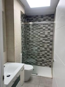 een badkamer met een douche, een toilet en een wastafel bij Aerofira Paterna in Paterna