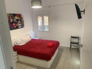 a bedroom with a red bed with a red blanket at Aerofira Paterna in Paterna