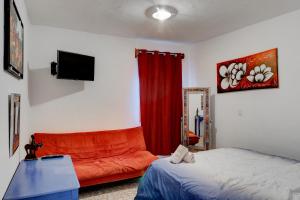 瓜納華托的住宿－Casa Palaxs，一间卧室配有一张床和一张红色的沙发