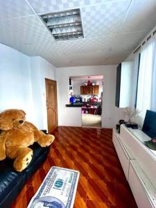 a teddy bear sitting on a couch in a living room at Departamento Suite frente al Mar in Manta