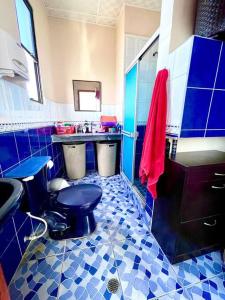 a blue tiled bathroom with a toilet and a sink at Departamento Suite frente al Mar in Manta